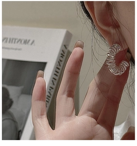 Gros plan de boucles d'oreilles créoles S925 en argent avec un design en spirale