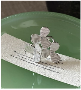 Macro detail of S925 sterling silver ring with three textured petals and center crystals