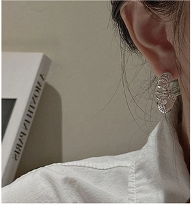 Gros plan détaillé des boucles d'oreilles créoles torsadées en argent S925 sur un mannequin