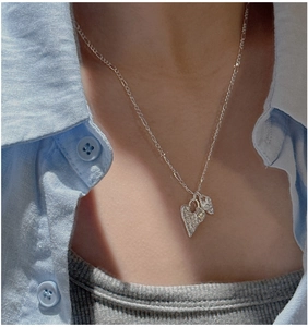 Close-up of S925 silver necklace with textured lava heart pendants on a model