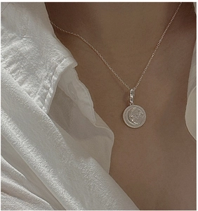 Close-up of S925 sterling silver crescent moon and star pendant on a minimalist chain