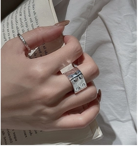 Detail view of S925 sterling silver square rings with hand-hammered texture on a model