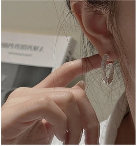 Gros plan sur des boucles d'oreilles créoles torsadées en argent S925 rétro