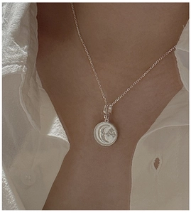 Detail of S925 sterling silver crescent moon and star pendant necklace on model