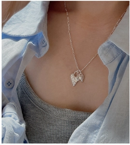 Close-up of S925 sterling silver Figaro chain with textured double heart pendants