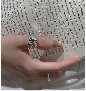 Detailed view of S925 sterling silver wide ring with hammered texture on a fashion magazine