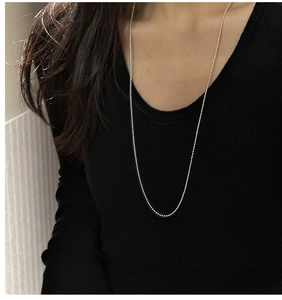 Minimalist long S925 sterling silver beaded sweater necklace on black garment