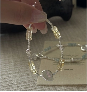 Detail of S925 silver beaded bracelet with faceted yellow crystal and baroque pearl