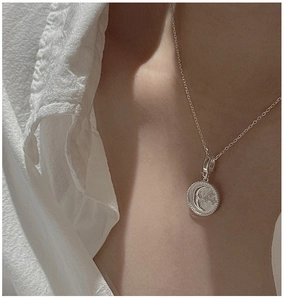 Detailed view of S925 silver crescent moon and star pendant on a delicate cable chain