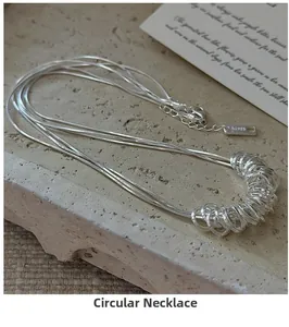 Close-up of S925 sterling silver multi-layer necklace with circular pendants on stone tray