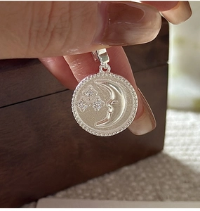 Macro shot of S925 sterling silver moon and star pendant with sparkling zircon accents