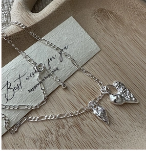 Detail of S925 silver necklace featuring lava heart and textured strawberry charms