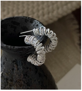 Vue détaillée de boucles d'oreilles spirales en argent sur un bol en céramique noir