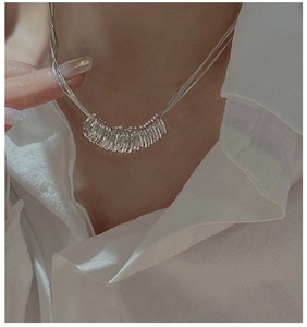 Detail of S925 sterling silver triple layer necklace worn on a white collared shirt