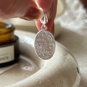S925 sterling silver daisy pendant featuring a relief flower pattern and sparkling zircon