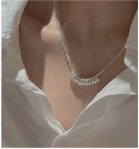 Detailed close-up of S925 sterling silver triple-layered snake chain necklace on model
