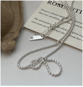 Macro detail of S925 sterling silver beaded necklace with lobster clasp and AG925 hallmark