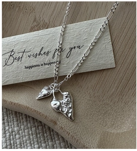 Detailed view of S925 silver necklace with textured heart pendants and Figaro chain