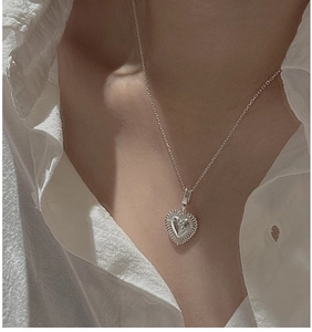 Detail shot of a S925 sterling silver heart pendant with radiant texture on a model
