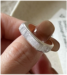 Close-up of S925 sterling silver ring with brushed matte finish and tiny embedded gem