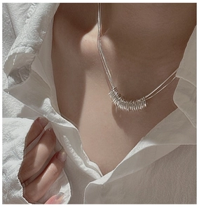 Detail of S925 sterling silver triple layered ring pendant necklace on a model