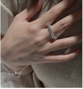 Close-up of S925 sterling silver wide ring with handcrafted hammered texture on finger