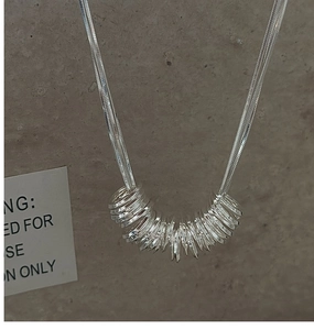 Close-up of S925 sterling silver triple-layered circle pendant on a sleek snake chain
