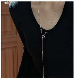 Detailed view of a silver S925 Y-shaped sweater necklace with piggy nose links on a model