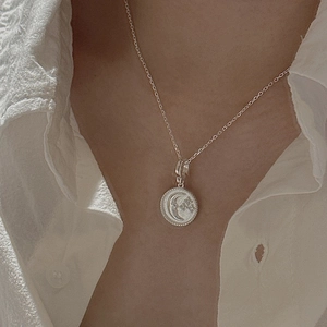 S925 sterling silver star and moon pendant necklace shown on a model with white shirt