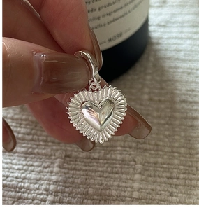 Detailed view of S925 silver heart pendant with sunburst texture and large hanging loop