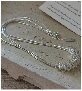 Macro shot of S925 sterling silver triple snake chain necklace with AG925 hallmark tag