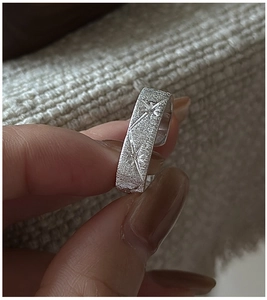 Macro shot of S925 sterling silver ring with textured matte finish and starburst engraving