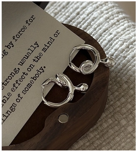 Close-up of S925 sterling silver minimalist twisted knot earrings with a polished finish