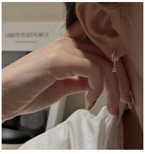 Close-up of S925 sterling silver twisted hoop earrings featuring a round zircon drop charm