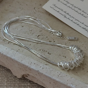 Three-layer S925 sterling silver snake chain necklace with Ag925 tag on sandstone tray