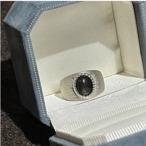 Dettaglio macro dell'anello in argento spazzolato con gemma nera ovale e pavé nel cofanetto