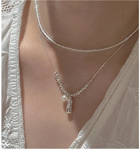 Close-up of S925 silver layered necklace with pearl and irregular bar pendant on model