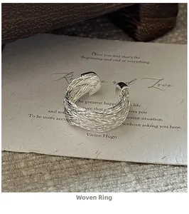 Macro shot of silver woven knot design ring on a vintage card background