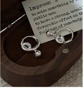 Macro shot of S925 sterling silver twisted knot earrings with a small zircon pendant