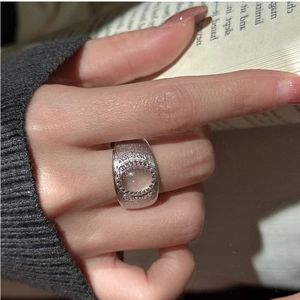 Detail of brushed S925 silver ring with oval translucent stone worn by a model