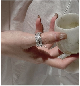 Macro detail of hand-woven S925 sterling silver ring showing intricate braided texture