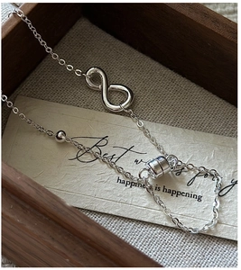 Detail of S925 sterling silver infinity bracelet with magnetic clasp on a gift card