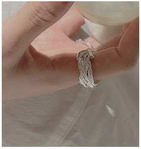 Close-up of a handmade S925 sterling silver woven cross ring with industrial minimalist style