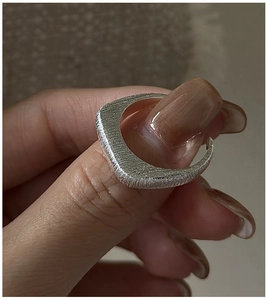 Macro detail of S925 sterling silver ring with brushed texture and geometric design
