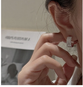 Detail of S925 sterling silver hoop earring with brushed texture and single zircon stone