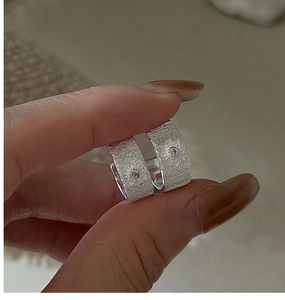 Detailed view of brushed S925 sterling silver hoop earrings with center crystal