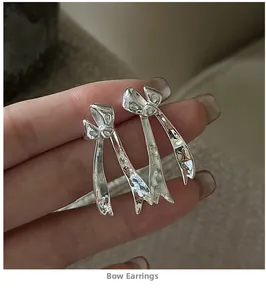 Detailed close-up of S925 silver liquid metal bow earrings with elegant long tassels