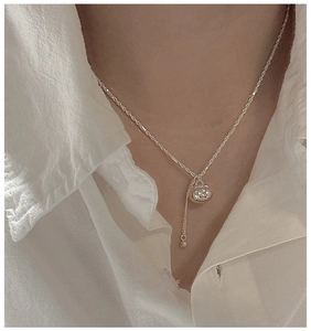 Detail of S925 sterling silver persimmon pouch pendant necklace worn on a woman's neck