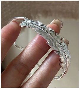 Macro view of detailed feather texture on a vintage S925 sterling silver open bangle