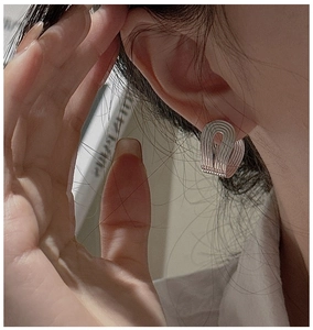Macro detail of silver U-shaped textured hoop earrings worn for a modern minimalist look